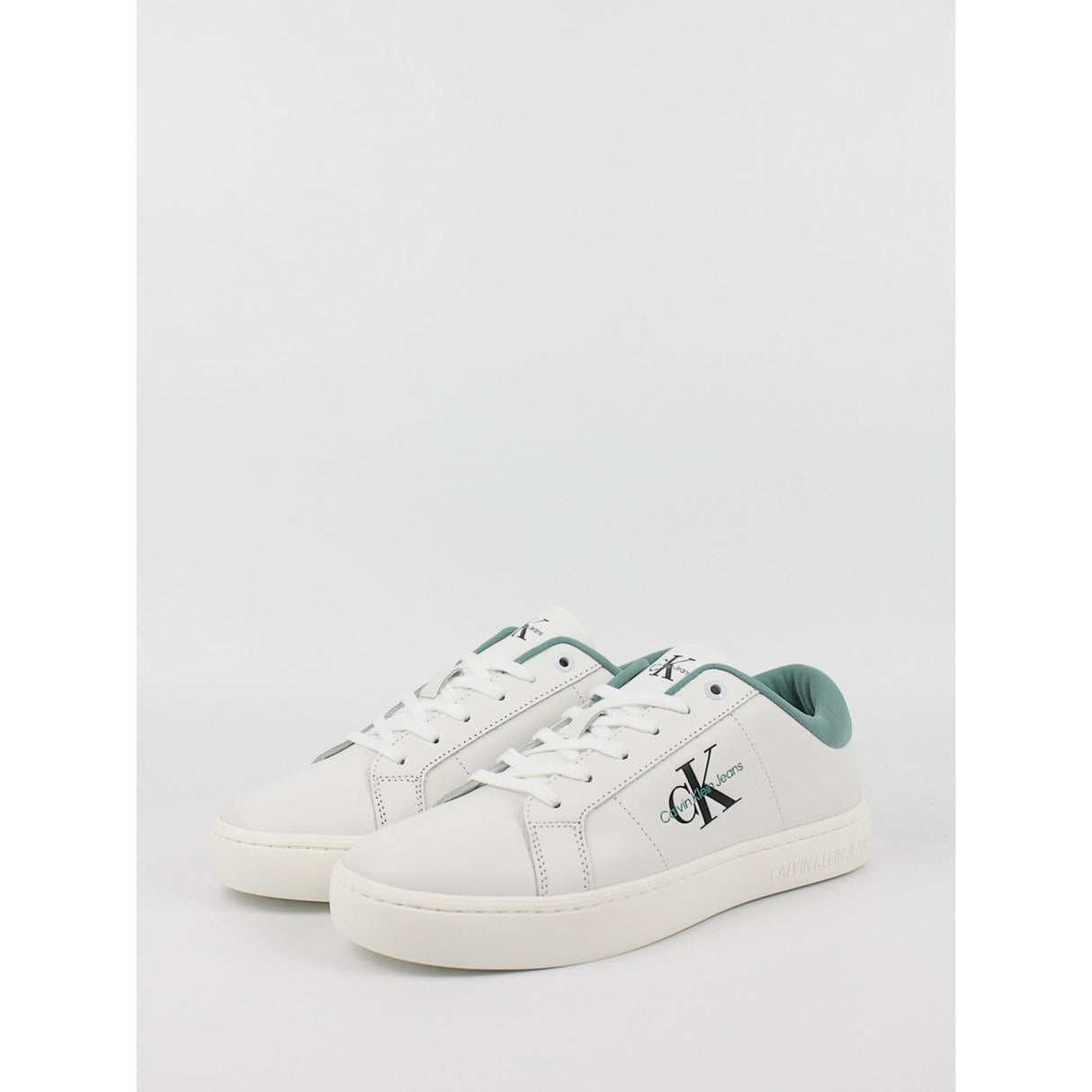 This is a pair of men's Calvin Klein Jeans Classic Cupsole Low Laceup sneakers in bright white leather with a turquoise/oil blue heel tab.