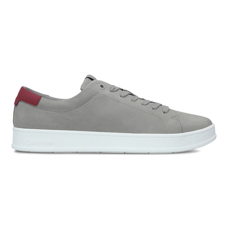 This is a pair of Calvin Klein low-top sneakers in grey with a white sole and red heel accent. Gray